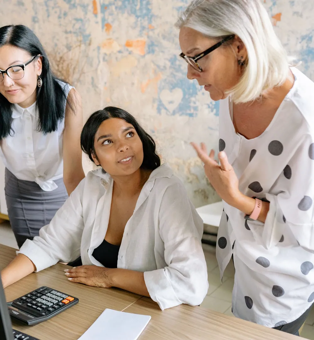 Três profissionais conversando sobre um projeto em volta de uma mesa