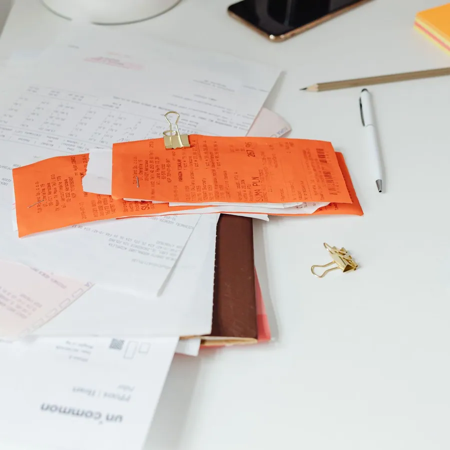 Mesa organizada com recibos, documentos e material de escritório