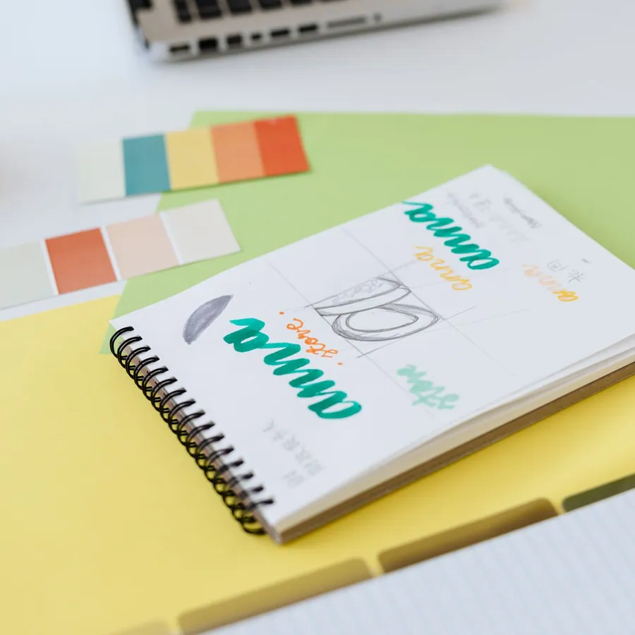 Caderno com esboços de logotipo e amostras de cores